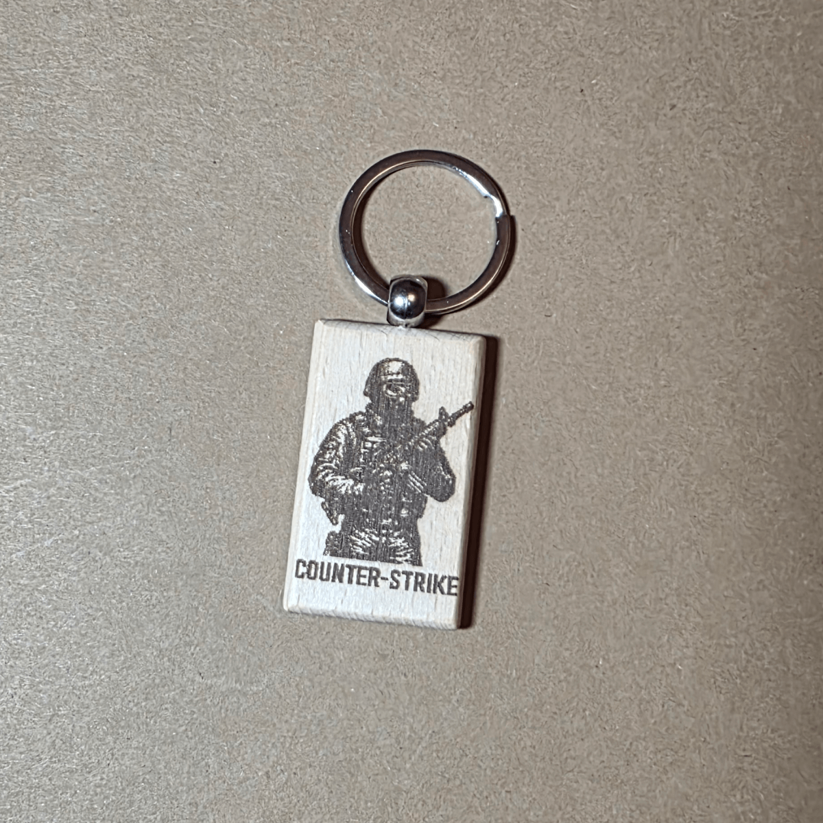 Counter-Strike laser engraved wooden keychain on neutral background