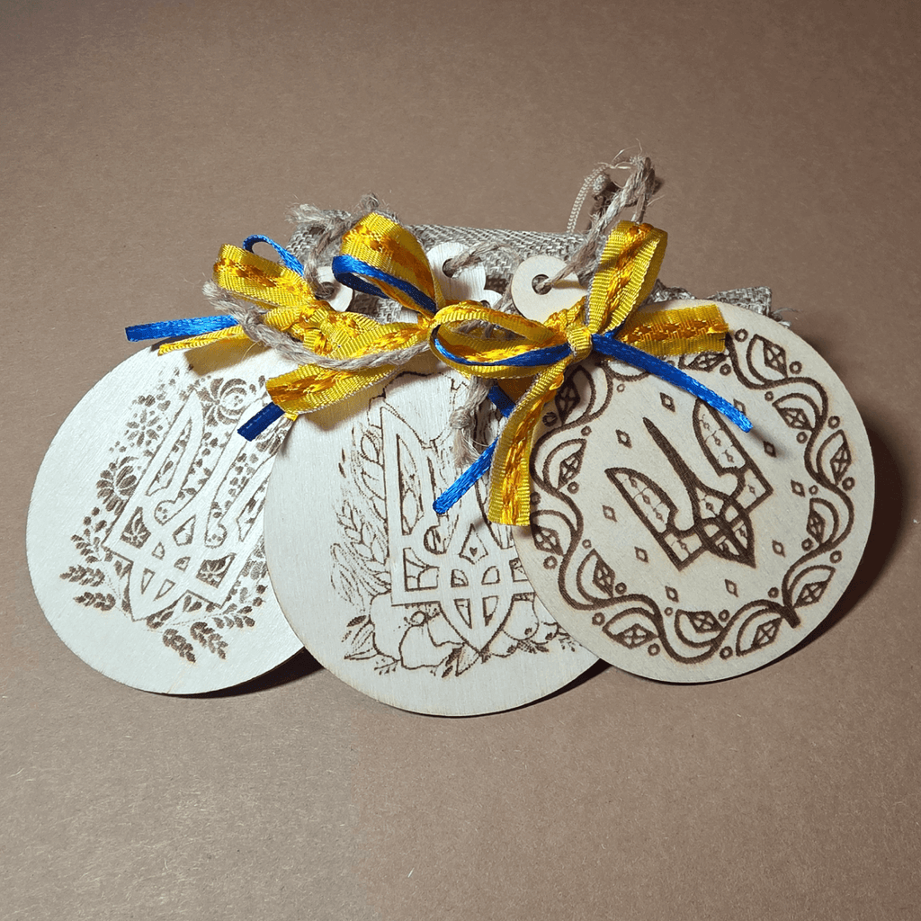 Laser-engraved Tryzub and holiday greetings on round wooden ornaments