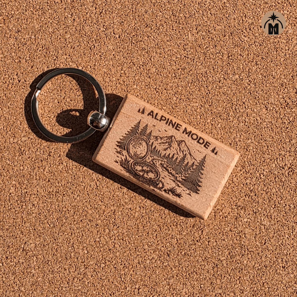 Beech wood keychain with alpine landscape engraving on natural background