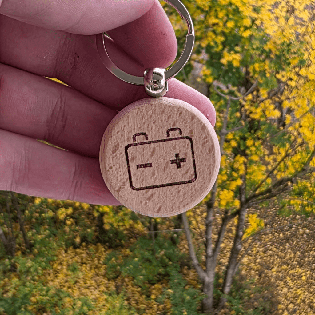 Battery/charging icon engraved on round wooden keychain