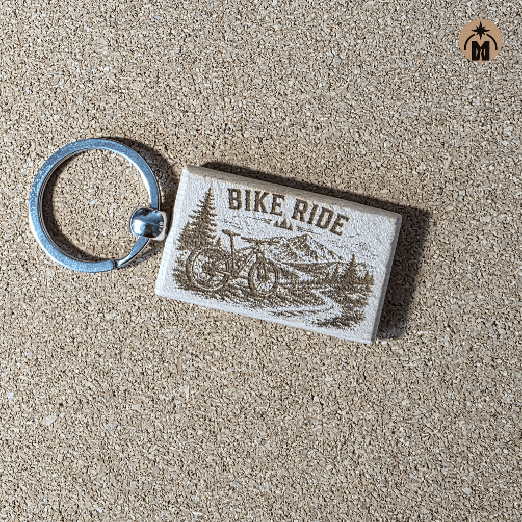 Wooden cycling keychain with bike trail design on natural background