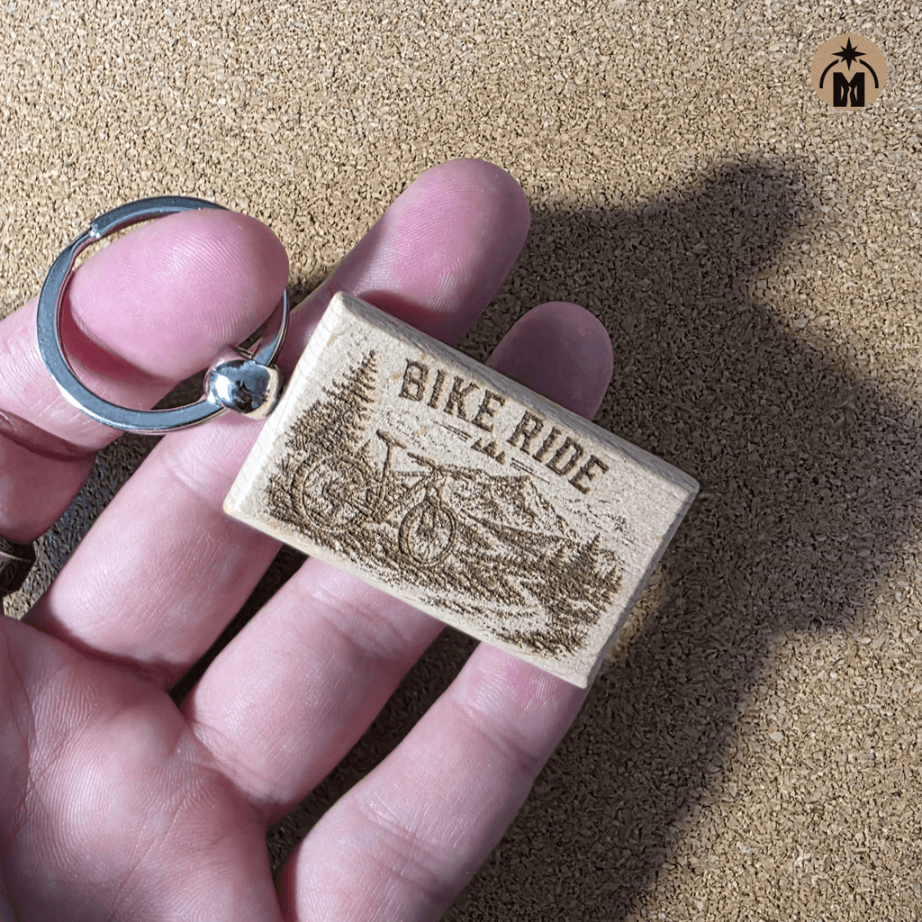 Laser engraved Bike Ride wooden keychain with bicycle and mountain landscape design
