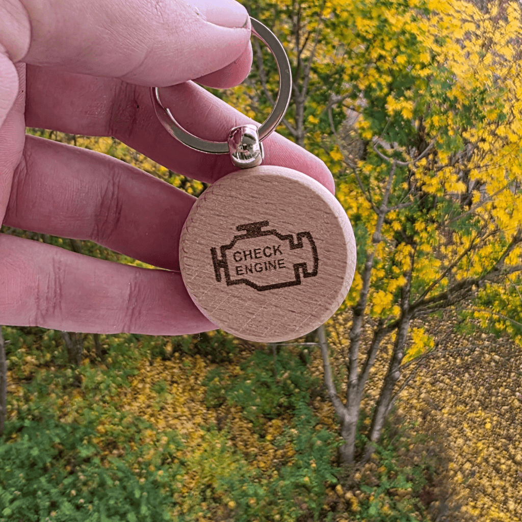 Check Engine icon engraved on round wooden keychain”