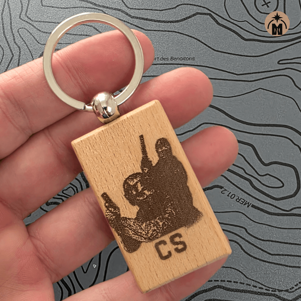 Laser engraved wooden CS gamer keychain with metal key ring on dark background