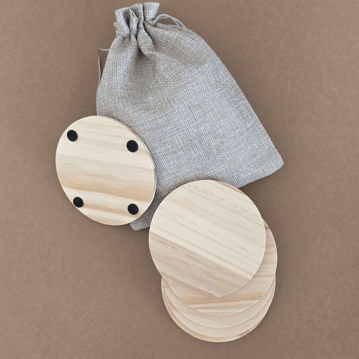 Wooden coasters 100 mm displayed with linen-style pouch