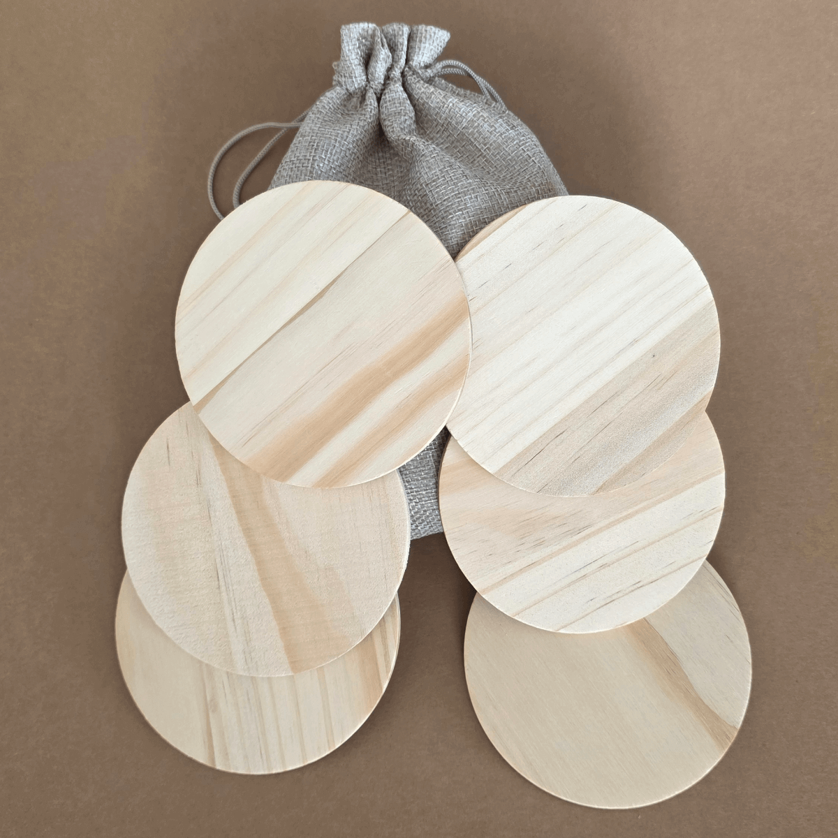 Set of six natural round wooden coasters with rubber feet and gift pouch