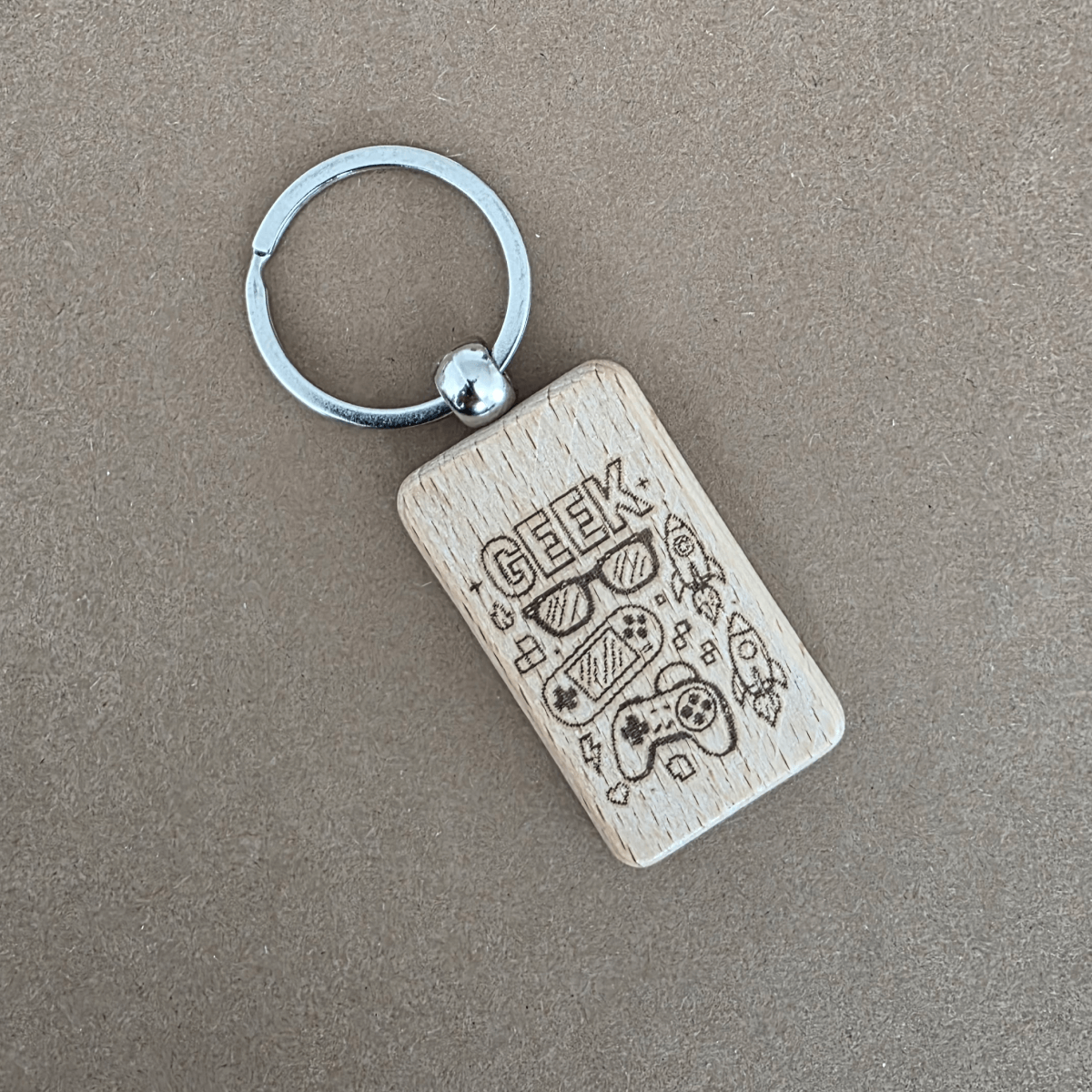Leseni obesek za ključe z gravuro Geek – ikone za igralce in tehnologijo (bukov les)