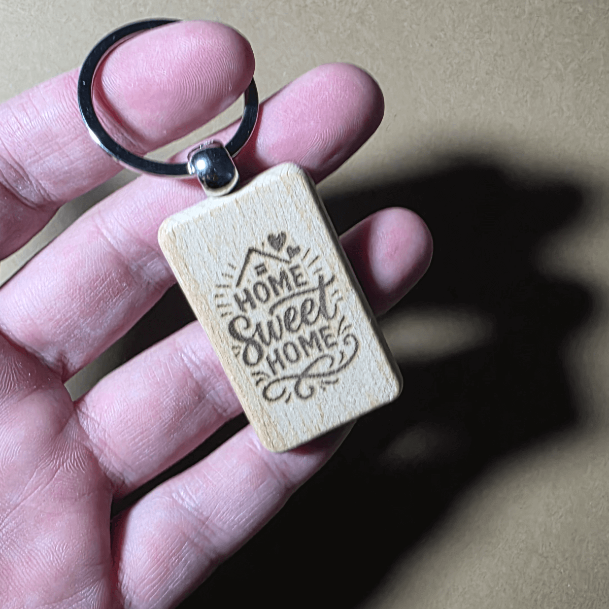 Natural wood “Home Sweet Home” housewarming key ring close up