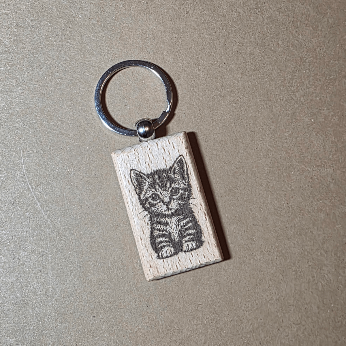 Engraved wooden keychain with cute kitten illustration on beech wood