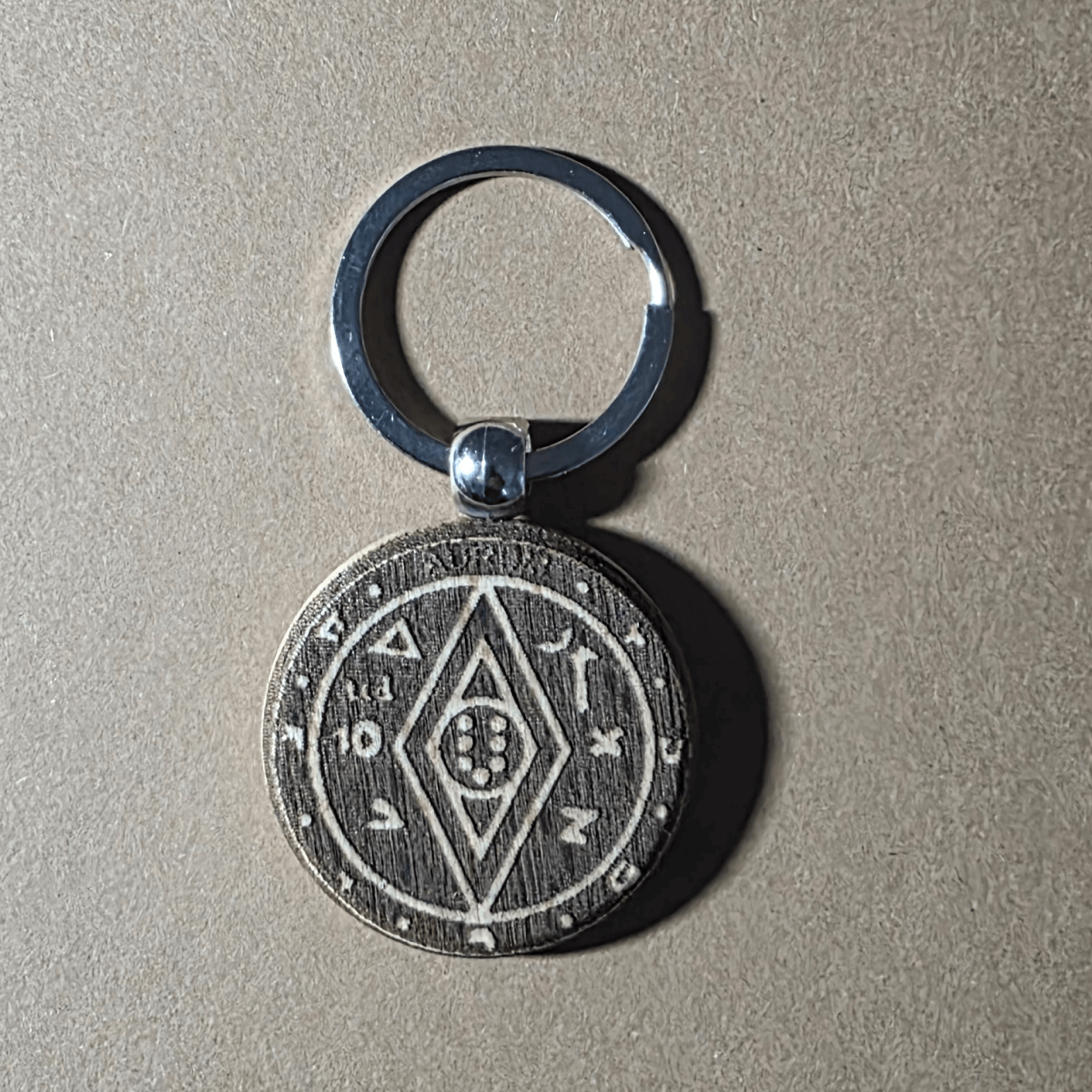 Money-luck talisman motif engraved on round wooden keychain