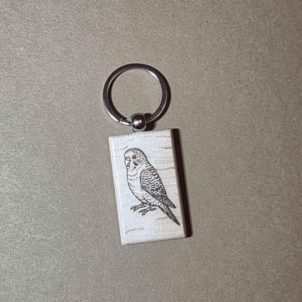 Laser engraved wooden keychain with detailed budgie illustration