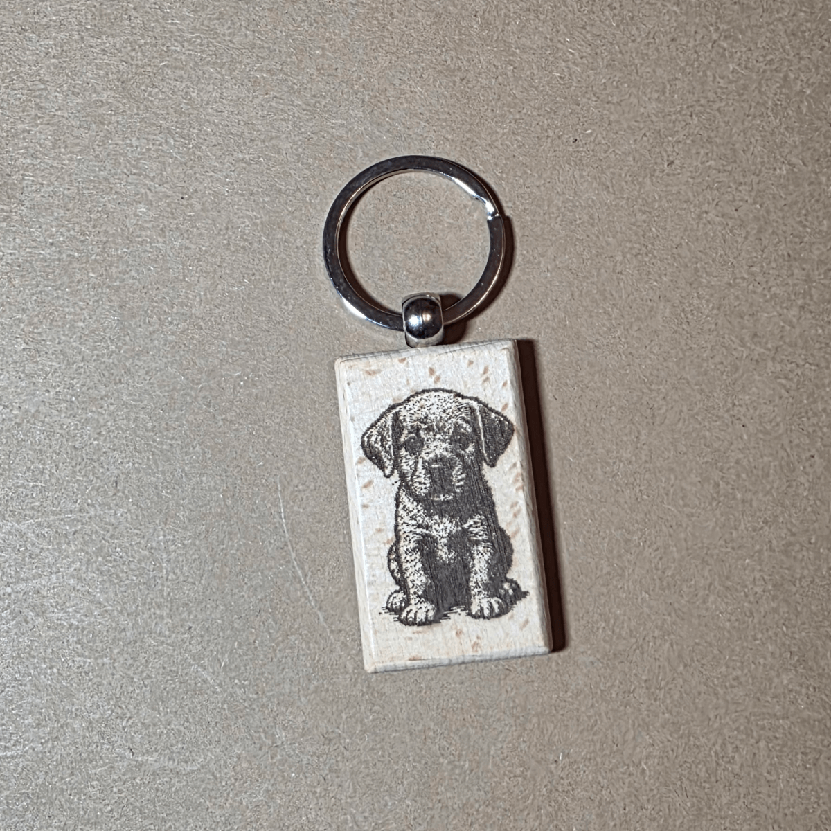 Engraved wooden keychain with cute puppy illustration on both sides