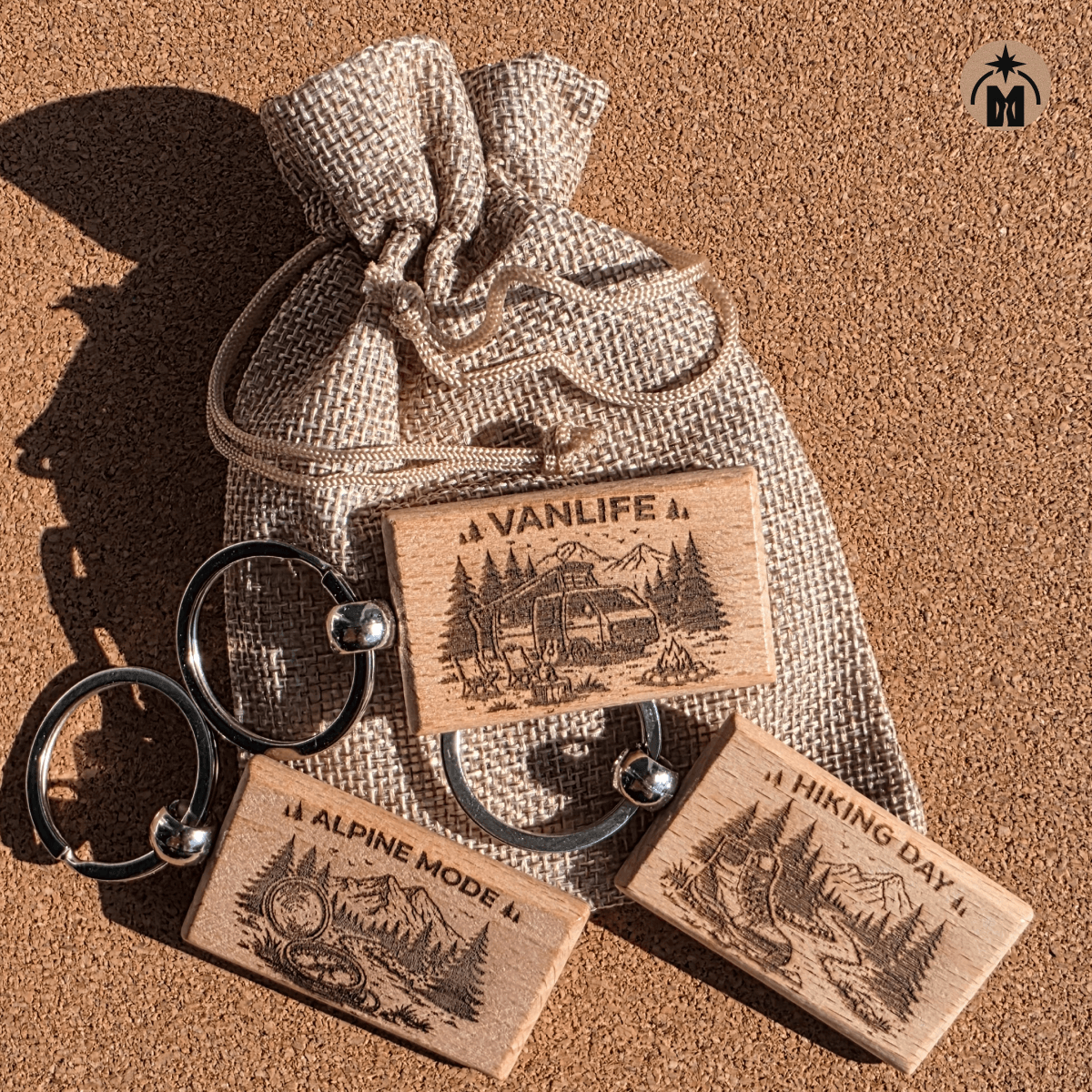 Set of three laser engraved wooden keychains in a fabric pouch: Vanlife, Alpine Mode, and Hiking Day