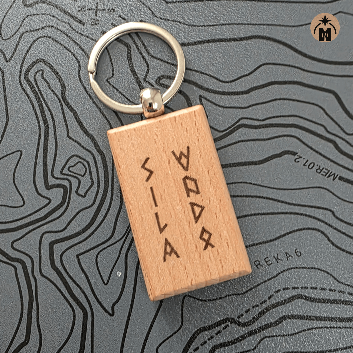 Close-up of wooden key fob with runic inscription Power of Water, metal key ring