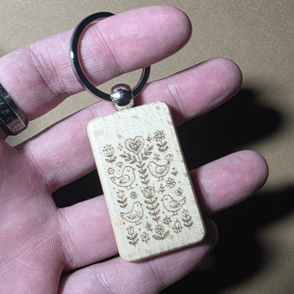 Natural rectangular wooden keyring with laser engraved bird and floral pattern