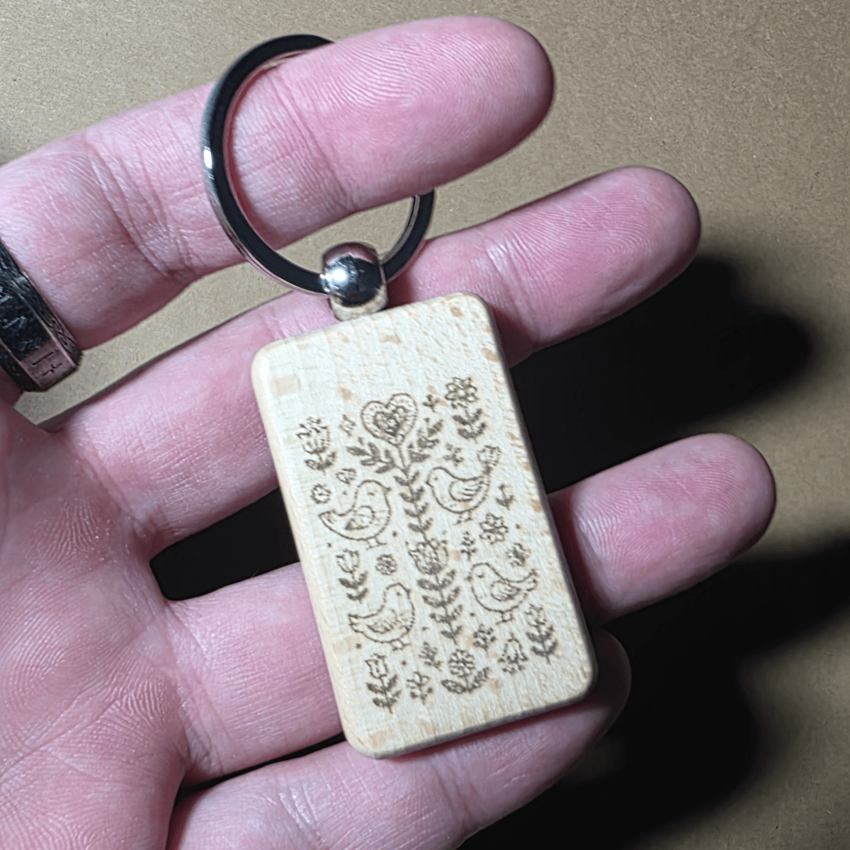 Natural rectangular wooden keyring with laser engraved bird and floral pattern