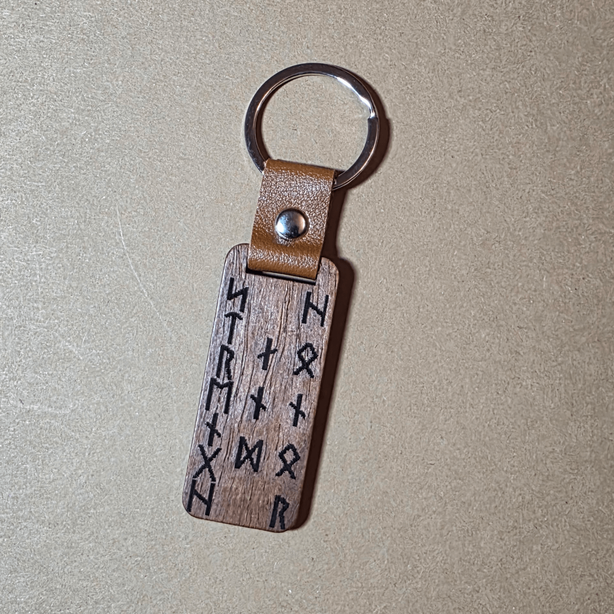 Engraved Viking warrior head and runic inscription Strength and Honor on dark wooden keyring