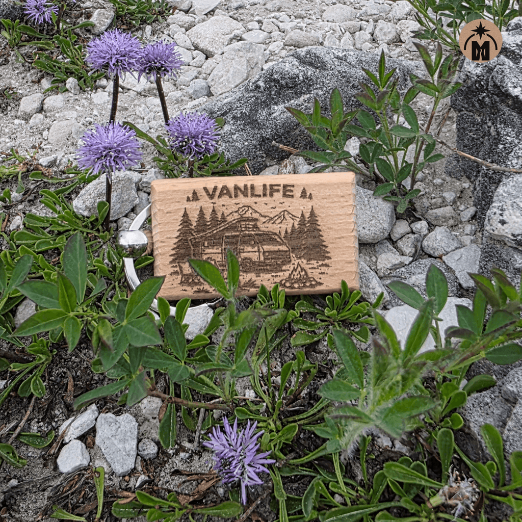 Beech wood keychain with vanlife engraving placed in a rocky natural landscape